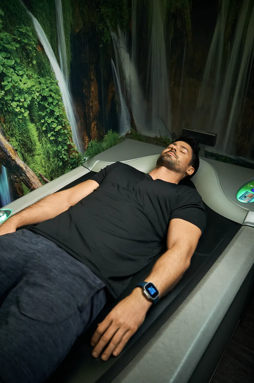 Frau entspannt sich auf der medi Lounge Wasserstrahl-Massageliege bei 100% Fitness Linden